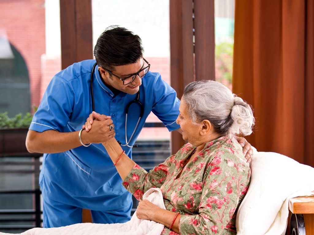 Caregiver providing attentive 24 hour care to an elderly person during a home visit.